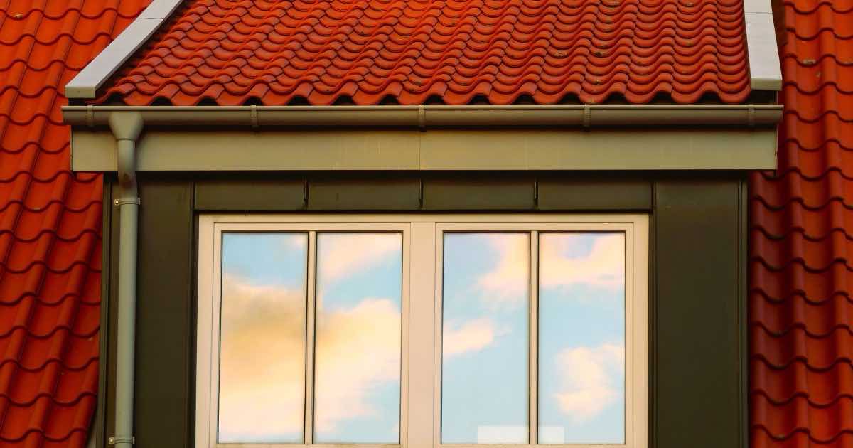 Dakkapel met raam in een rood pannendak