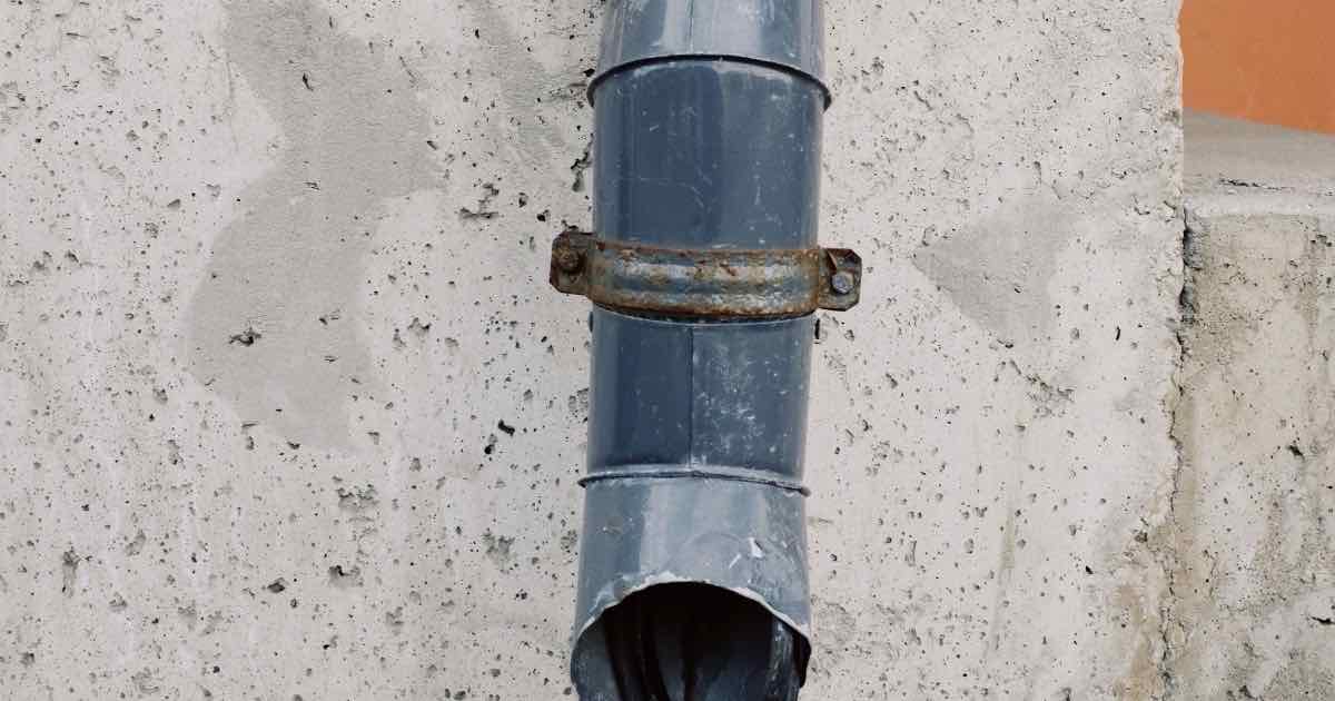 Afvoerbuis langs een betonnen muur