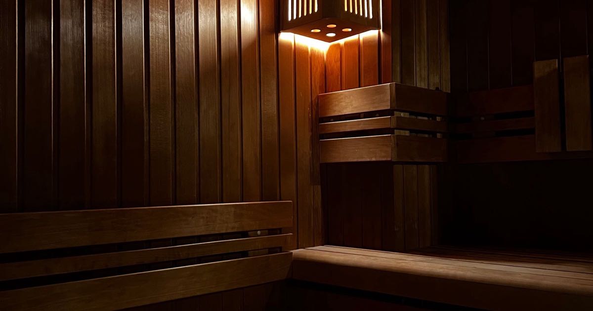 Donkere houten sauna met banken en warm licht